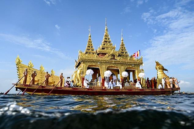 Devotees row a golden barge carrying four sacred Buddha images during the Phaung Daw Oo pagoda festival in Myanmar